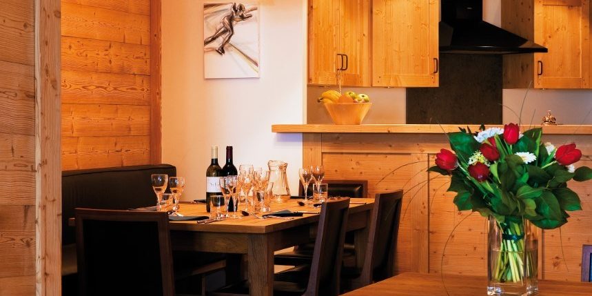 Appartement Petit Choucas Val d'Isere Tignes & Val d'Isere Frankrijk wintersport skivakantie luxe eetkamer gedekte tafel wijn hanglamp bloemen keuken blauw kussen