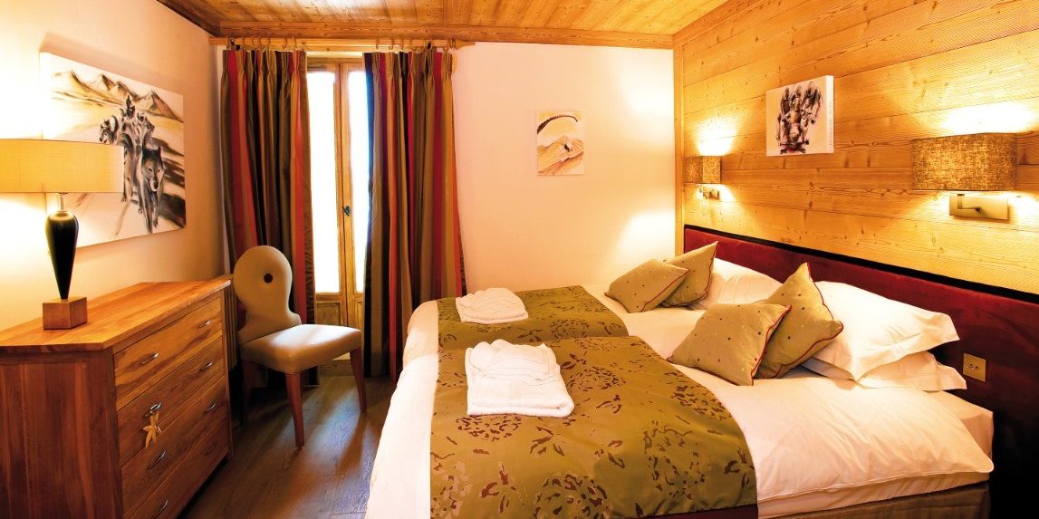 Appartement Petit Choucas Val d'Isere Tignes & Val d'Isere Frankrijk wintersport skivakantie luxe slaapkamer aparte bedden handdoeken houten kast lamp stoel hout