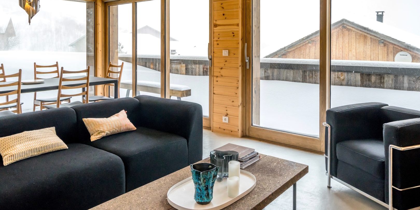 Appartement by U no. 3 Saint Martin de Belleville Les 3 Vallees Frankrijk wintersport skivakantie luxe living bank kaarsen fauteuil hoge ramen eetkamer hanglamp