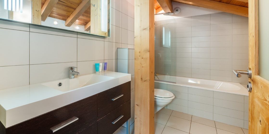 Chalet Alaska Morzine Les Portes du Soleil Frankrijk wintersport skivakantie luxe badkamer bad wastafel spiegel pilaar toilet houten balken