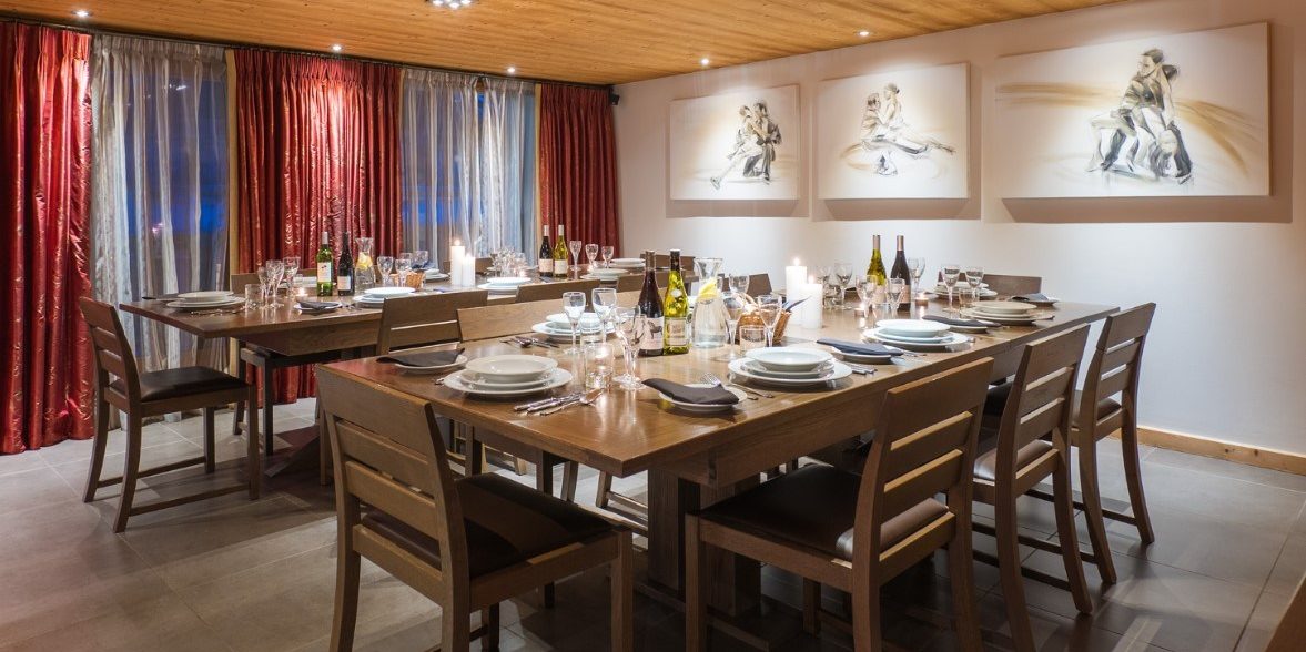 Chalet Alaska Morzine Les Portes du Soleil Frankrijk wintersport skivakantie luxe eetkamer gedekte tafels kaarsen wijn wijnglazen schilderijen verlichting hout