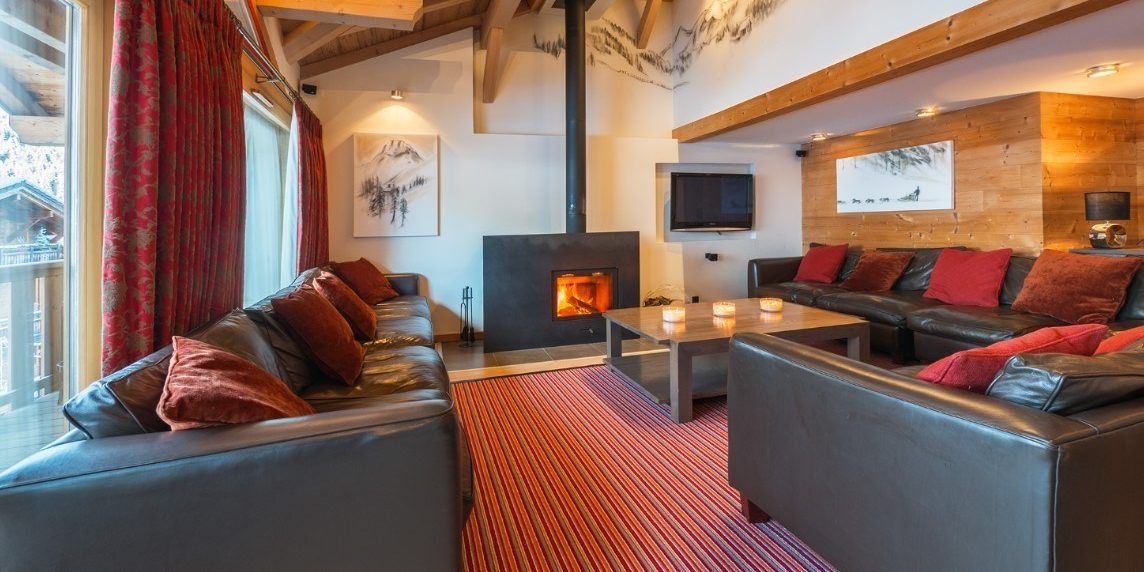 Chalet Alaska Morzine Les Portes du Soleil Frankrijk wintersport skivakantie luxe living leren banken kussens open haard vloerkleed ramen houten balken