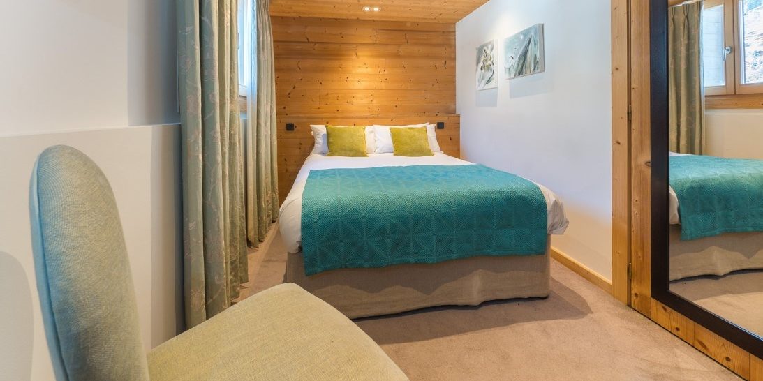 Chalet Alaska Morzine Les Portes du Soleil Frankrijk wintersport skivakantie luxe slaapkamer 2-persoonsbed stoel schilderijen verlichting hout