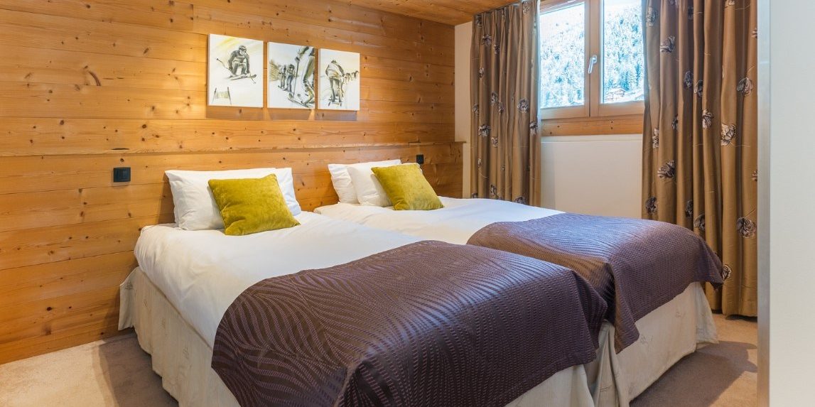 Chalet Alaska Morzine Les Portes du Soleil Frankrijk wintersport skivakantie luxe slaapkamer aparte bedden bedsprei schilderijen raam hout