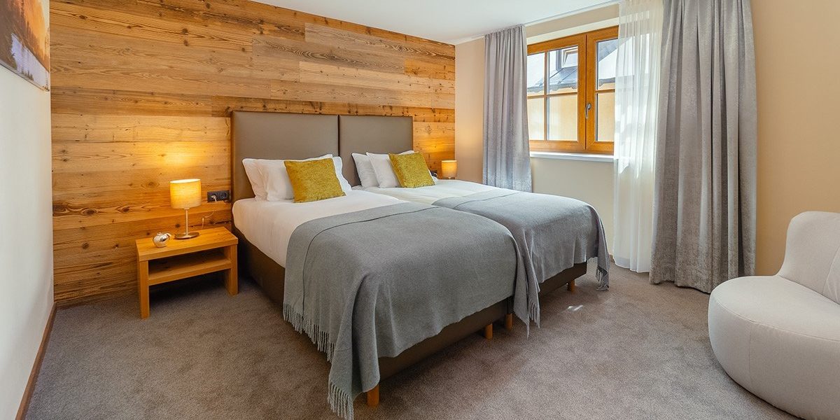 Chalet Cristal Sankt Anton Arlberg Oostenrijk wintersport skivakantie luxe 2 aparte bedden hoofdbord kussens fauteuil hout lamp raam