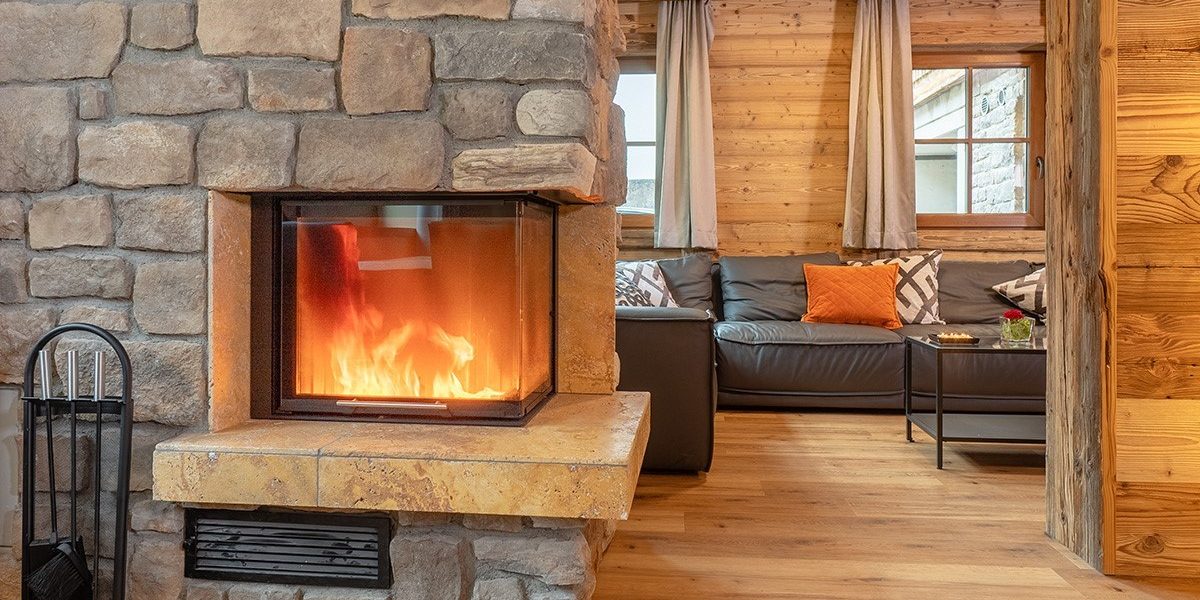 Chalet Cristal Sankt Anton Arlberg Oostenrijk wintersport skivakantie luxe living open haard stenen hout loungebank kussens ramen