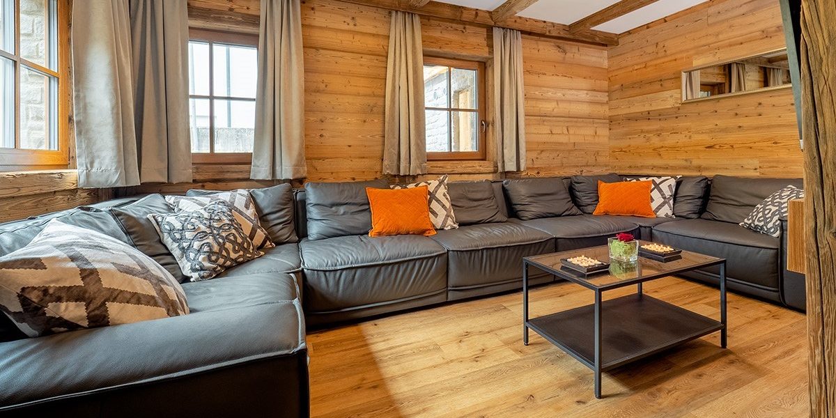 Chalet Cristal Sankt Anton Arlberg Oostenrijk wintersport skivakantie luxe living zithoek lounge hoekbank salontafel ramen houten balken