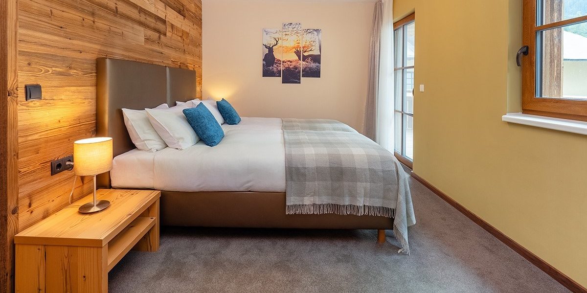 Chalet Cristal Sankt Anton Arlberg Oostenrijk wintersport skivakantie luxe slaapkamer 2 aparte bedden hoofdbord bedsprei schilderijen raam