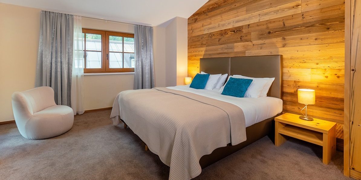 Chalet Cristal Sankt Anton Arlberg Oostenrijk wintersport skivakantie luxe slaapkamer 2-persoonsbed fauteuil nachtlamp hout raam