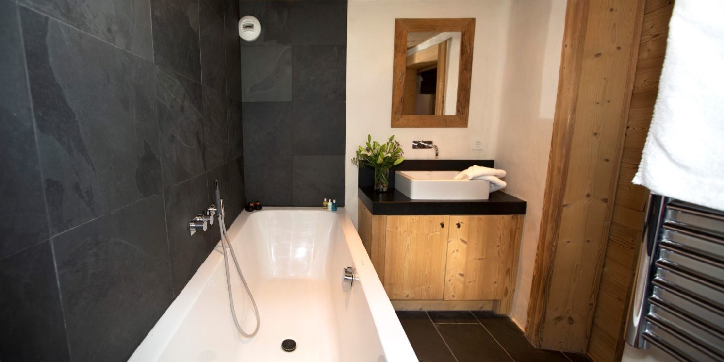Chalet La Petite Ferme Val d'Isere Tignes & Val d'Isere Frankrijk wintersport skivakantie luxe badkamer bad wastafel spiegel handdoekenrek
