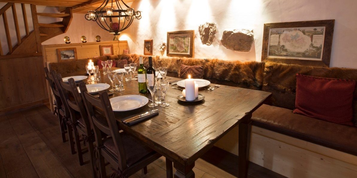 Chalet La Petite Ferme Val d'Isere Tignes & Val d'Isere Frankrijk wintersport skivakantie luxe eetkamer gedekte tafel kaarsen wijn bank schilderij hanglamp