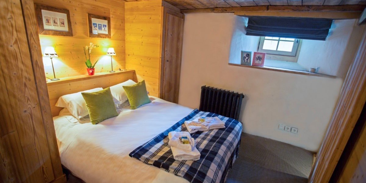 Chalet La Petite Ferme Val d'Isere Tignes & Val d'Isere Frankrijk wintersport skivakantie luxe slaapkamer 2-persoonsbed handdoeken schilderijen hout