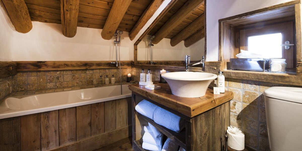 Chalet Lafitenia Val d'Isere Tignes-Val d'Isere Frankrijk wintersport skivakantie luxe badkamer bad wastafel handdoeken spiegel houten balken