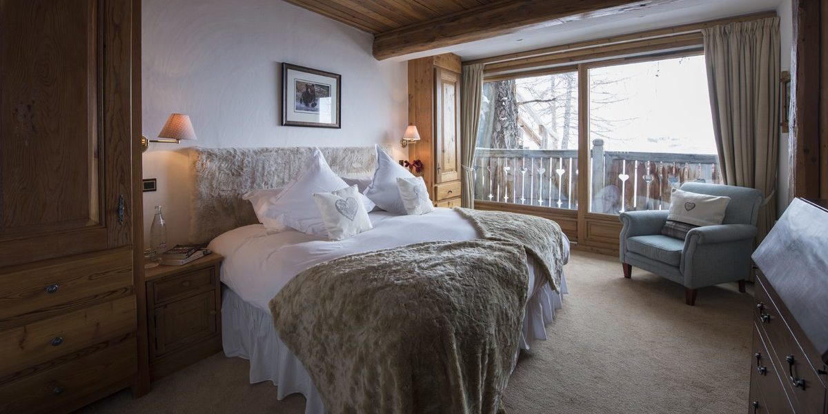 Chalet Lafitenia Val d'Isere Tignes-Val d'Isere Frankrijk wintersport skivakantie luxe slaapkamer 2-persoonsbed fauteuil schilderij hout raam balkon bomen