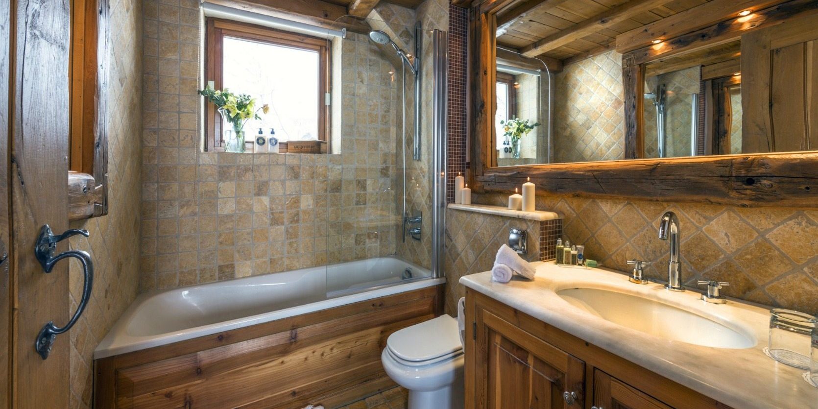 Chalet Le Chardon Val d'Isere Tignes-Val d'Isere Frankrijk wintersport skivakantie luxe badkamer bad wastafel spiegel kaarsen bloemen raam toilet
