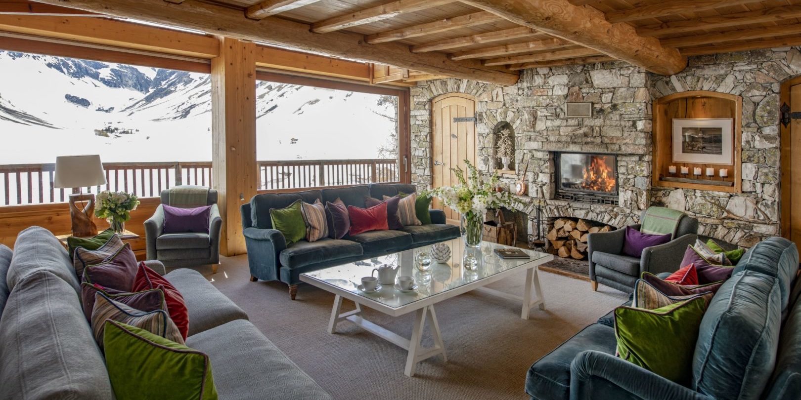 Chalet Le Chardon Val d'Isere Tignes-Val d'Isere Frankrijk wintersport skivakantie luxe living lounge banken open haard high tea fauteuil grote ramen houten balken