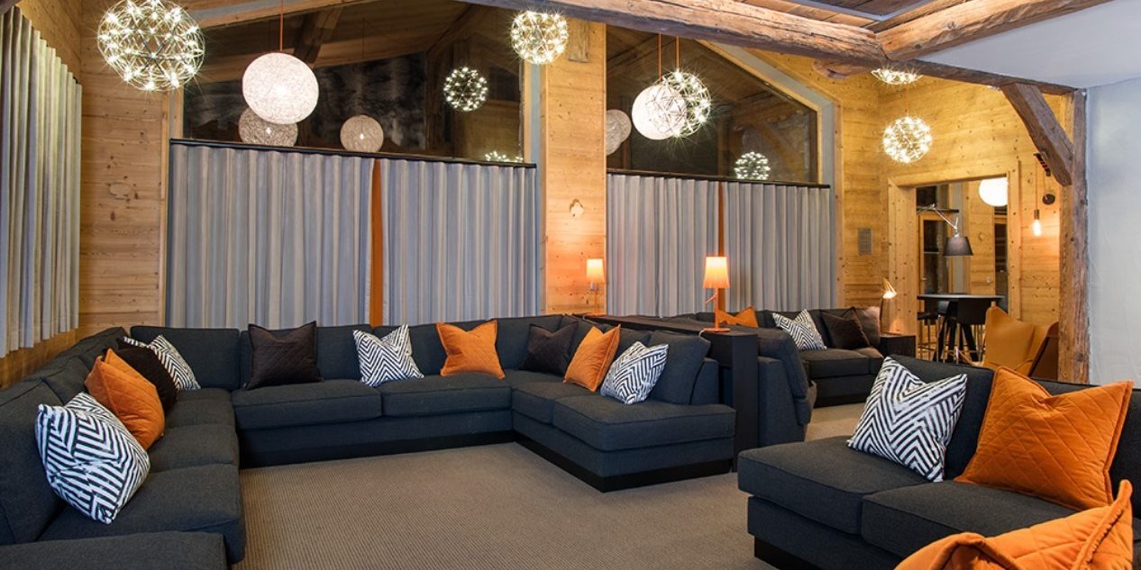 Club Bellevarde Lodge Val d'Isere Tignes & Val d'Isere Frankrijk wintersport skivakantie luxe living lounge hoekbank kussens hanglampen hoge ramen hout
