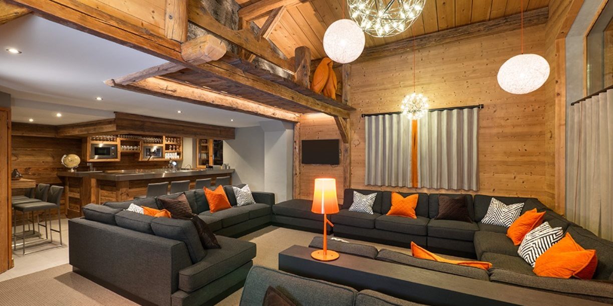 Club Bellevarde Lodge Val d'Isere Tignes & Val d'Isere Frankrijk wintersport skivakantie luxe living lounge hoekbank kussens hanglampen hout houten balken