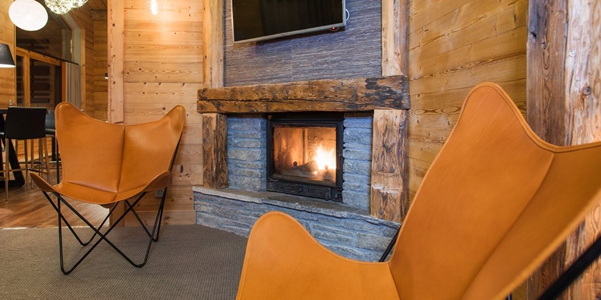 Club Bellevarde Lodge Val d'Isere Tignes & Val d'Isere Frankrijk wintersport skivakantie luxe living open haard fauteuils TV hanglampen hout