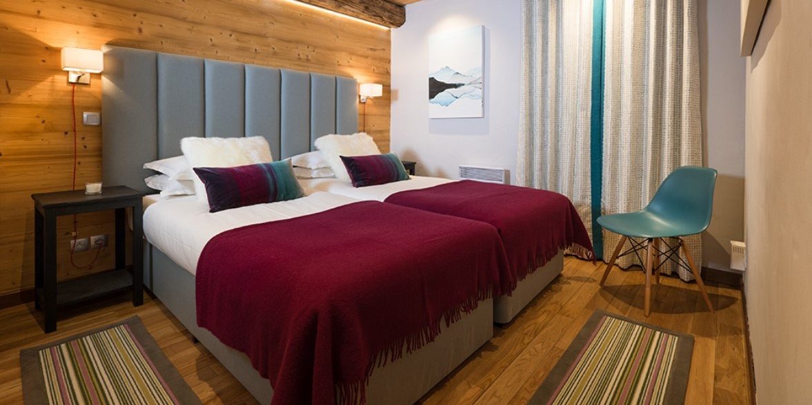 Club Bellevarde Lodge Val d'Isere Tignes & Val d'Isere Frankrijk wintersport skivakantie luxe slaapkamer aparte bedden bedsprei vloerkleed stoel hout