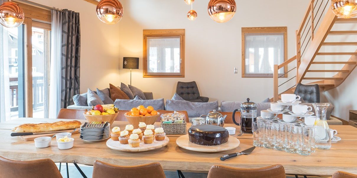 Colibri Penthouse Morzine Les Portes du Soleil Frankrijk wintersport skivakantie luxe gedekte eettafel ontbijt brood cake fruit taart koffie hanglampen