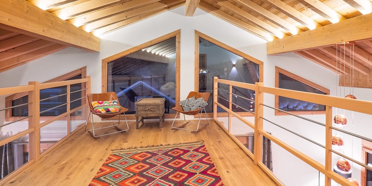 Colibri Penthouse Morzine Les Portes du Soleil Frankrijk wintersport skivakantie luxe mezzanine stoelen vloerkleed ramen houten balken
