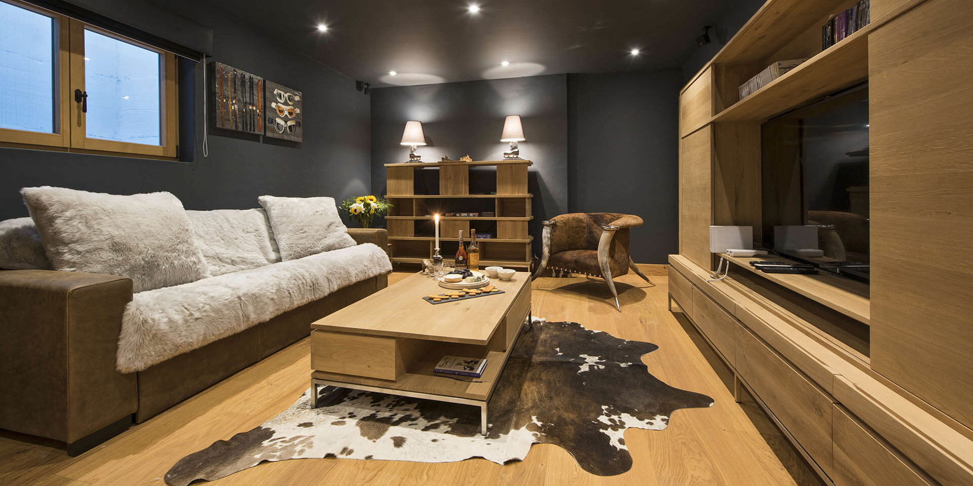 Penthouse Sherwood Verbier Les 4 Vallees Zwitserland wintersport skivakantie luxe TV kamer bank salontafel vloerkleed verlichting schilderijen raam