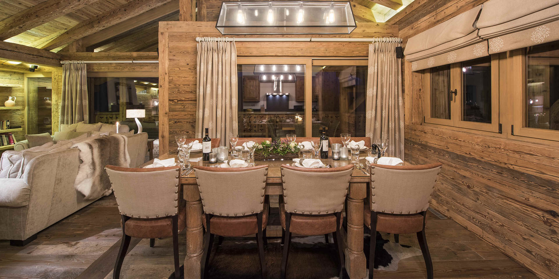 Penthouse Sherwood Verbier Les 4 Vallees Zwitserland wintersport skivakantie luxe eetkamer gedekte tafel wijn wijnglazen plant hanglamp ramen houten balken