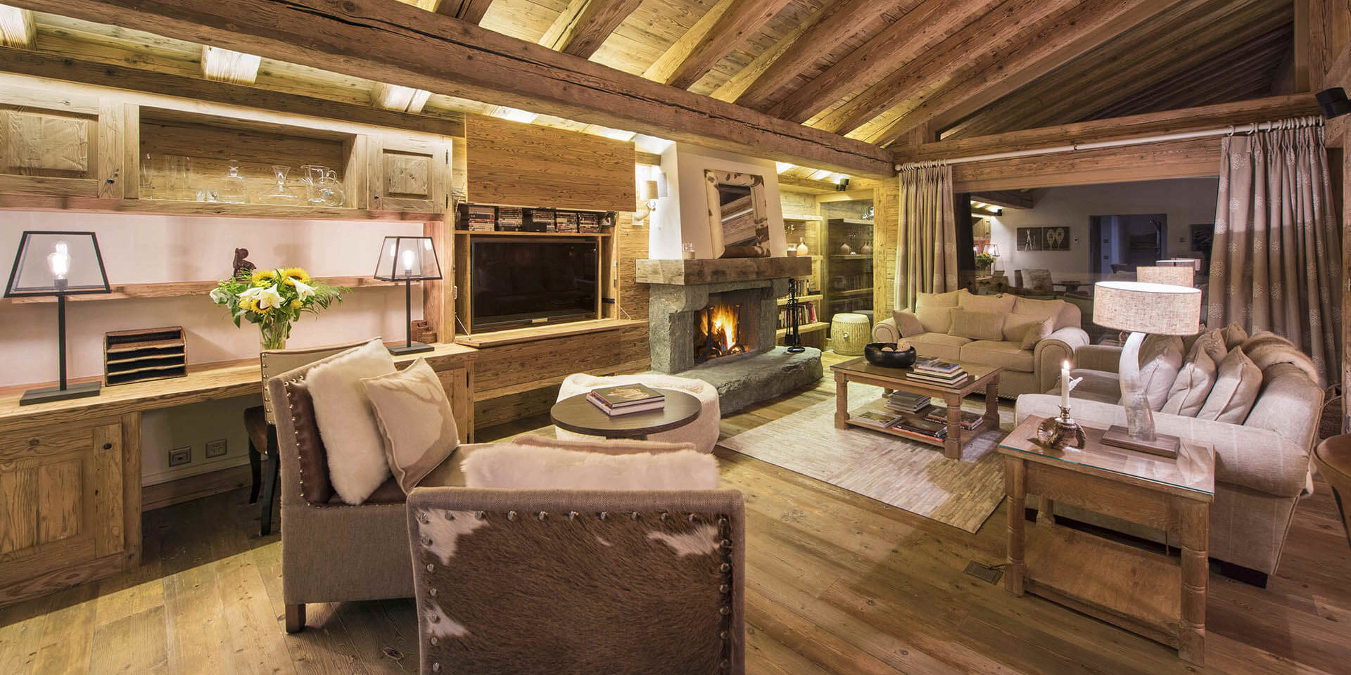 Penthouse Sherwood Verbier Les 4 Vallees Zwitserland wintersport skivakantie luxe living fauteuils banken vloerkleed open haard bloemen houten balken raam