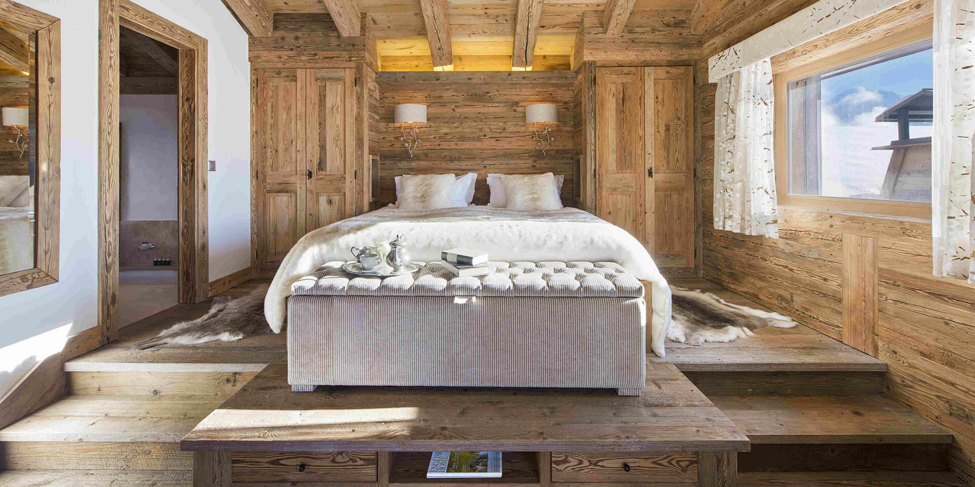 Penthouse Sherwood Verbier Les 4 Vallees Zwitserland wintersport skivakantie luxe slaapkamer 2-persoonsbed trapjes verlichting houten balken raam