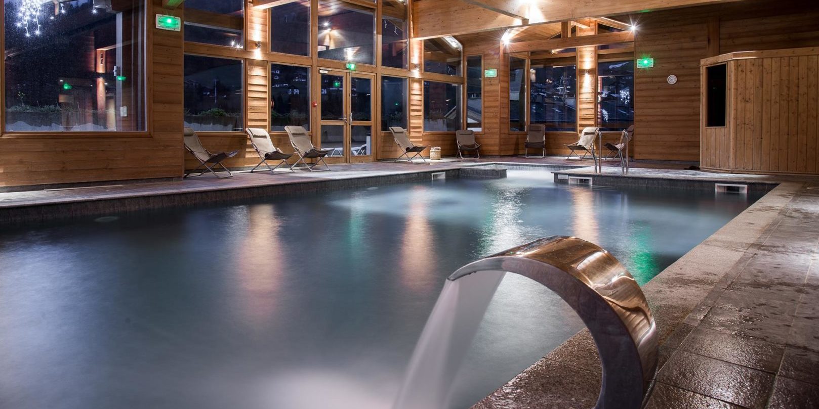 Residence Les Grandes Alpes La Clusaz Aravis Frankrijk wintersport skivakantie luxe zwembad ligstoelen ramen houten balken ontspannen relaxen genieten