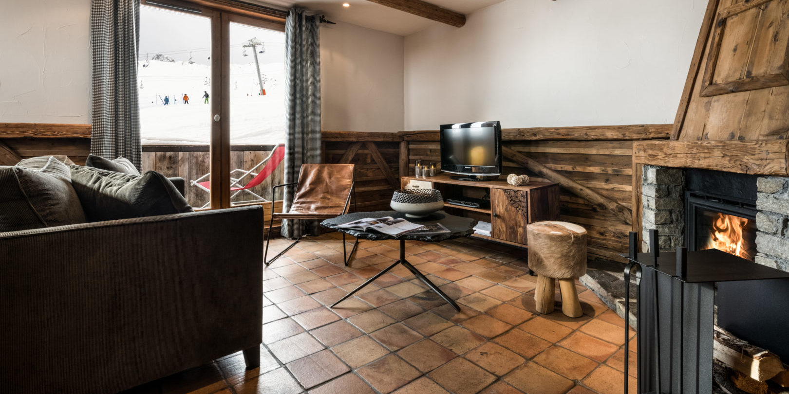 Hotel Les Suites du Montana Tignes Tignes-Val d'Isere Frankrijk wintersport skivakantie luxe suite living open haard bank fauteuil krukje raam